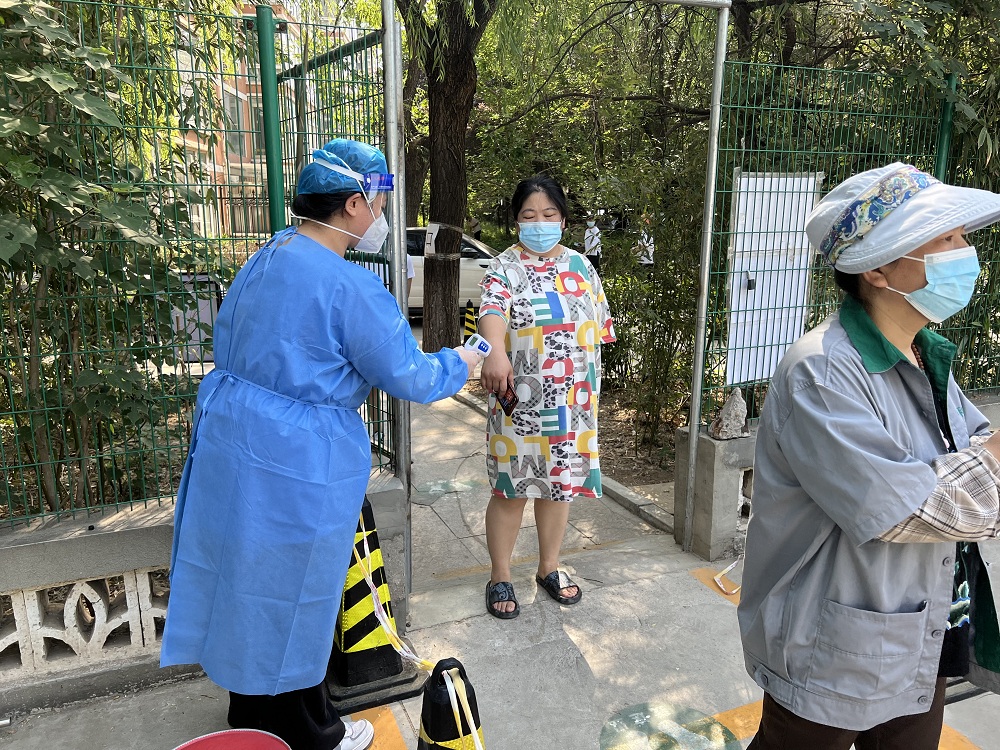 志愿者在核酸检测入口为居民测量体温.JPG